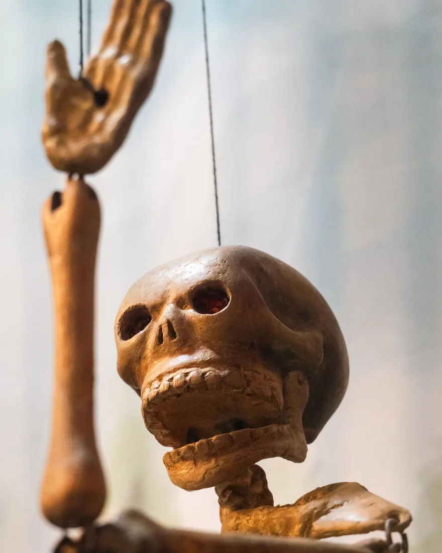 Detalle de una figura articulada de madera donde se aprecian las uniones de hombro, codo y rodilla